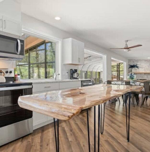 Open-plan kitchen with a live-edge wood island and large windows